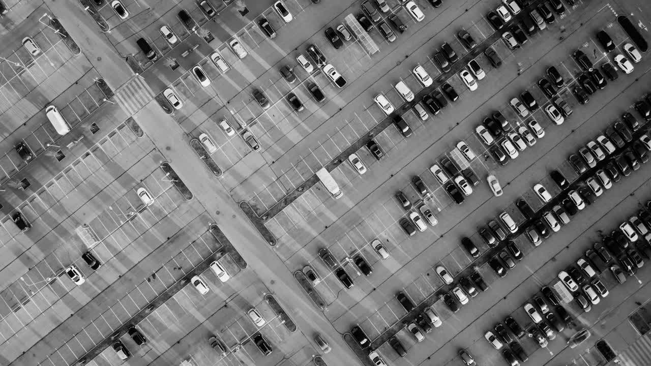 Dynamic timelapse shows Riga parking lot in motion from top-down grayscale view
