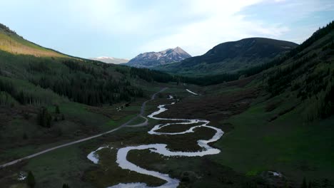 a meandering fresh-water river is seen from above in the mountain valleys on a beautiful summer day near crested butte, colorado