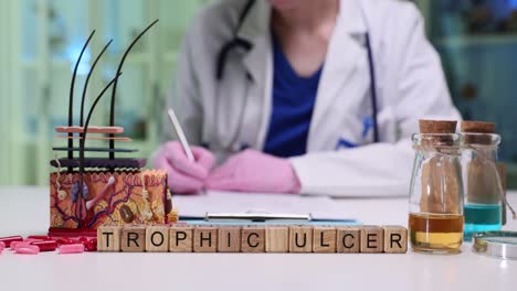a doctor writing notes with a skin anatomy model and 'trophic ulcer' blocks on the desk, representing dermatological study