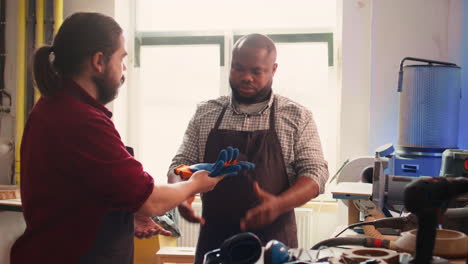 cabinetmaker ensures apprentice uses safety earmuffs before starting work
