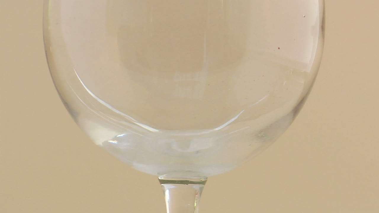 un vertido a cámara lenta de vino tinto en una copa de vino