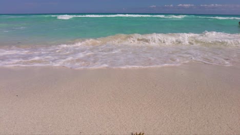 close up of the waves at the beach in cancun mexico with the blue and turquoise caribbean sea in the back
