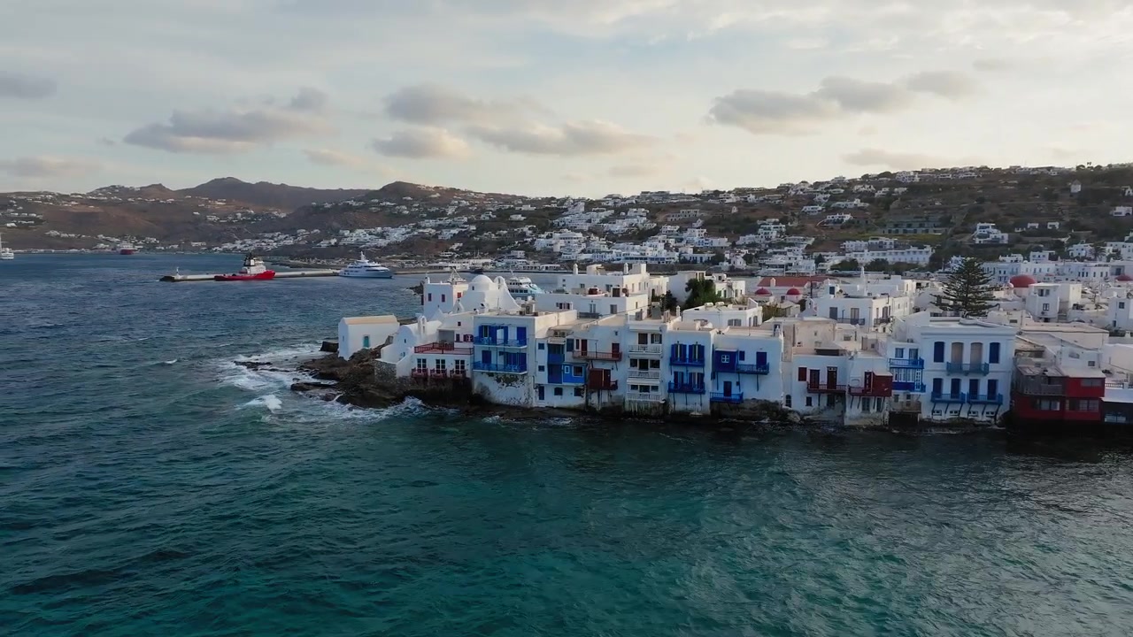 Pequena Veneza na orla de Mykonos com casas brancas e ondas ao longo da costa rochosa, Grécia