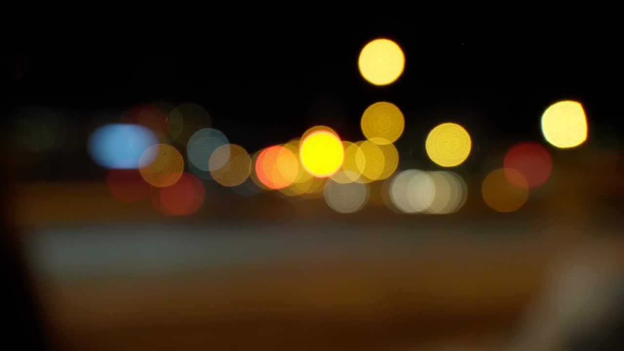 bokeh en fondo oscuro borroso por la noche. el colorido bokeh redondo brilla de las luces de los coches en la calle de la ciudad. concepto abstracto.