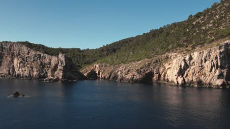 Slow-cinematic-drone-shot-of-cliffs-and-rocks-along-coast-with-ocean