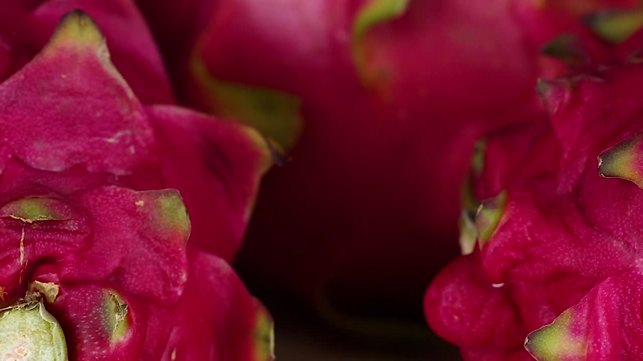 Detailed view of dragon fruit skin highlighting its vibrant pink color and unique texture.