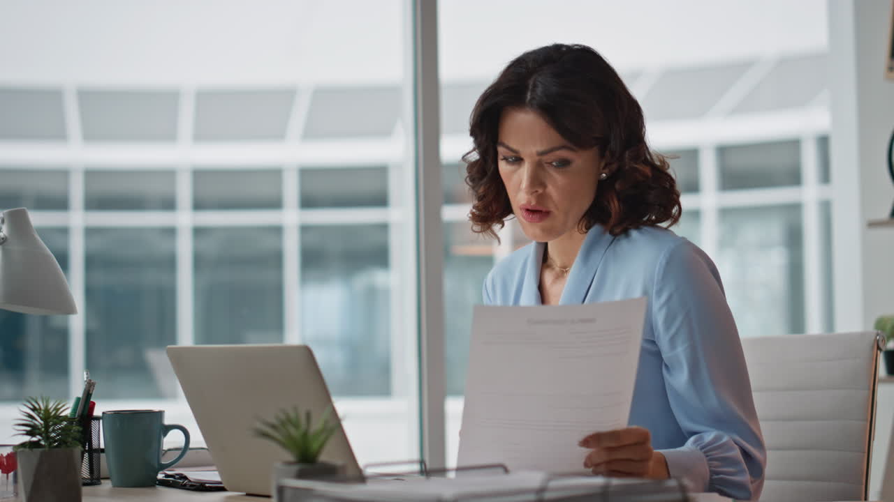 Fatigued businesswoman reading document feeling overloaded at office closeup