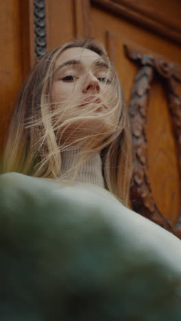 woman with blonde hair by wooden door