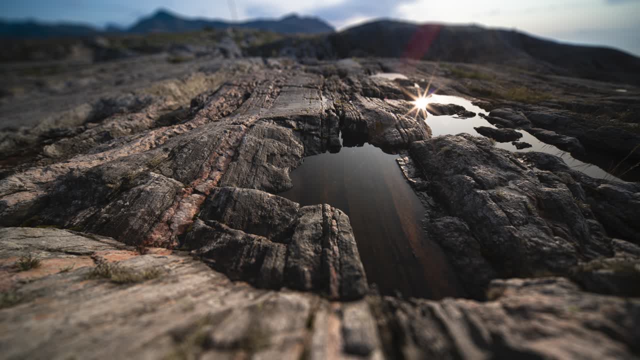 A small water pool in the dark withered rocks