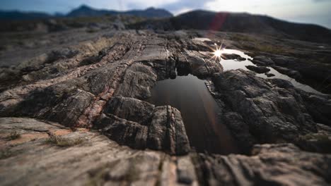 una pequeña piscina de agua en las rocas secas oscuras