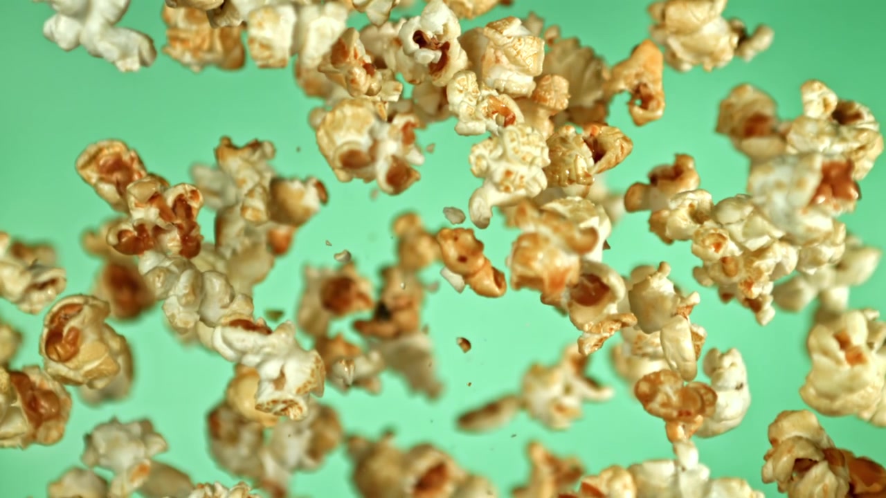 Popcorn Flying and Floating in Slow Motion on Green Background