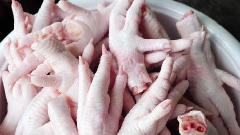 Close-up-shot-uncooked-Chicken-feet-on-pan-ready-to-cook---Slow-motion