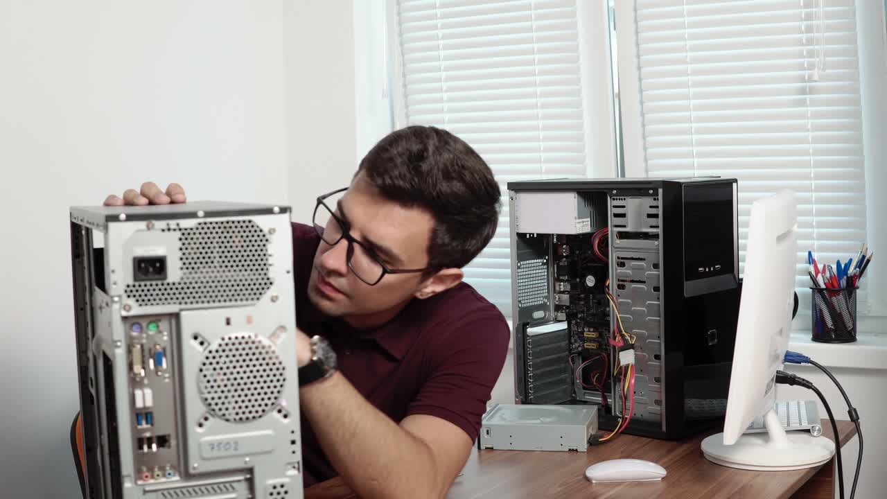 trabajador de servicio de computadoras concentrado reparando una computadora rota en la oficina y actualizando el hardware de la computadora. equipo de apoyo. mantenimiento de computadoras. filmado en 4k