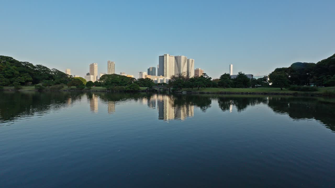 Tokyo lake reflecting skyscrapers. A peaceful blend of urban and nature. Ideal for projects needing urban development and serene natural contrast. 4K, 60p.