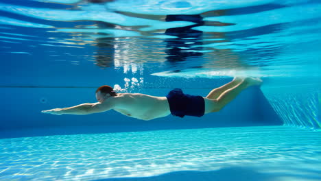 hombre nadando bajo el agua en una piscina