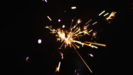 lit party sparkler sparkling on black background