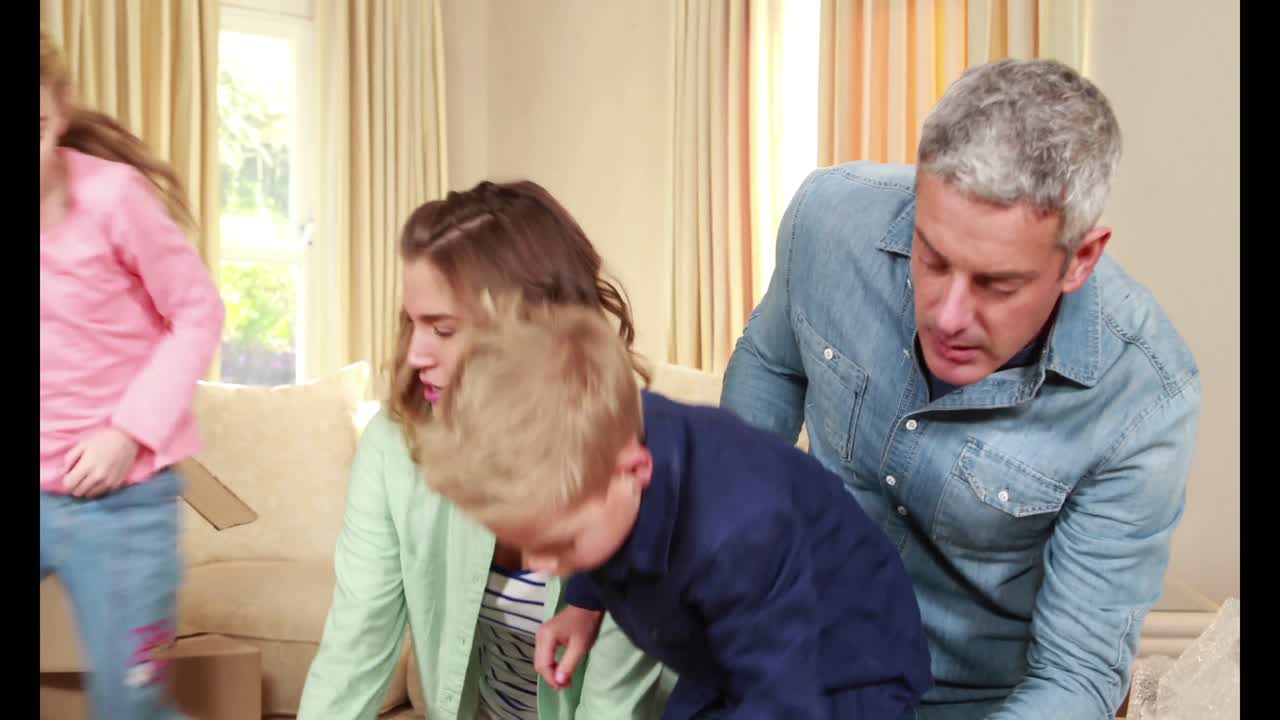 가족 들 이 움직이는 상자 들 을 풀고 있다