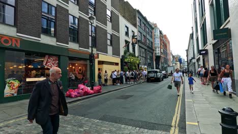 people walking past a food shop in london