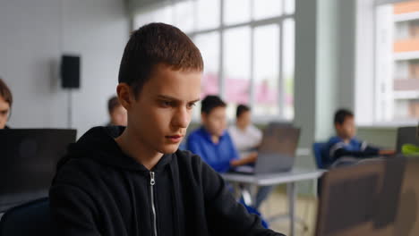 students working on laptops in a classroom