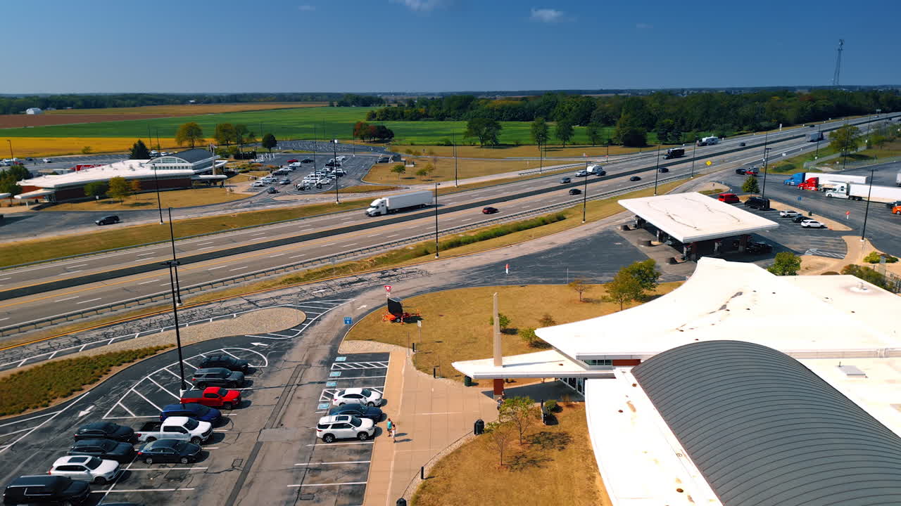 Chicago, USA, 29 June 2025: Aerial drone view of a gas station and highway traffic surrounded by green farmland on a clear sunny day