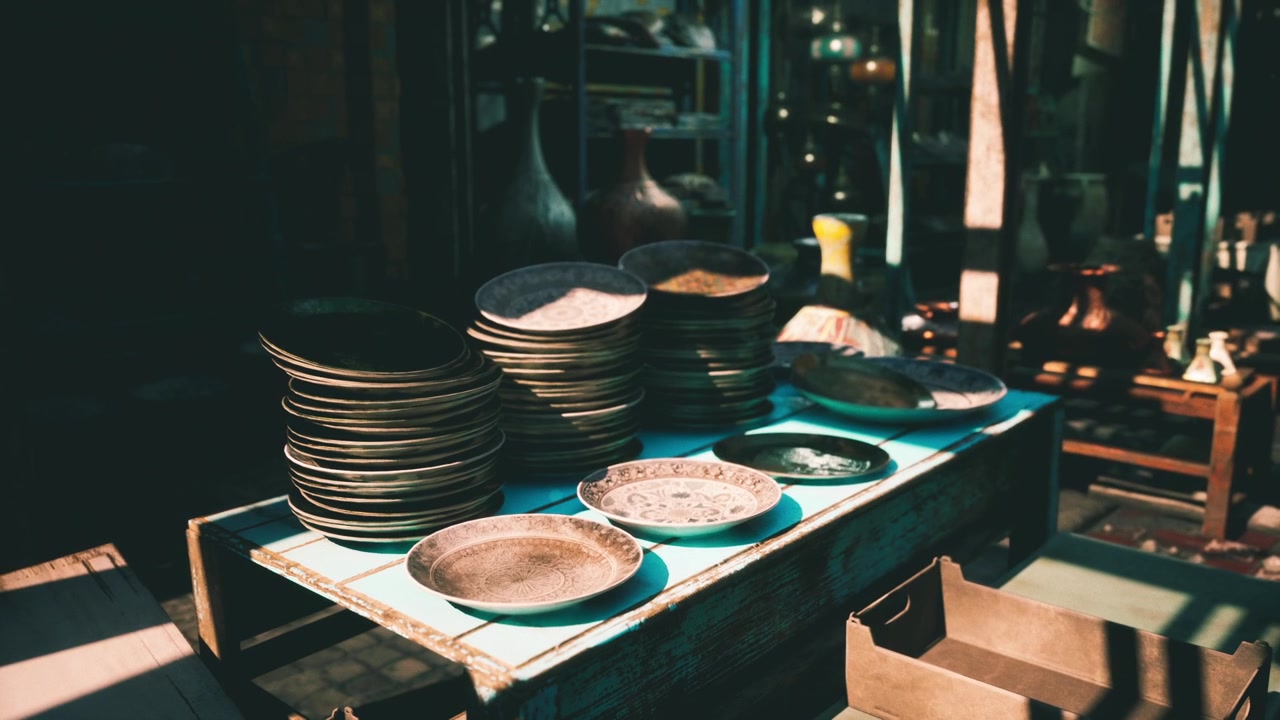 Stacked plates on a wooden table in a bustling marketplace in the afternoon
