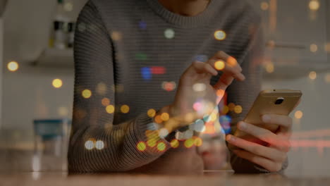manchas de luces bokeh contra un hombre caucásico que usa un teléfono inteligente en casa