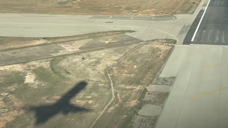 sombra de un avión en el suelo durante un aterrizaje en tiempo real como se ve desde la cabina
