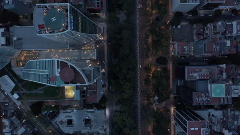 Aerial-birds-eye-overhead-top-down-panning-view-of-traffic-in-streets-of-downtown.-Flying-drone-in-evening,-after-sunset.-Mexico-City,-Mexico.