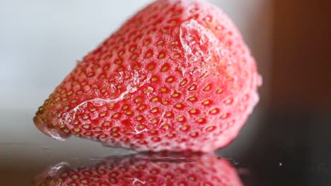 frozen-strawberry-with-reflection,-macro-close-up