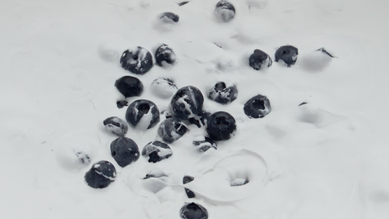 신선한 블루베리 요거트는 슈퍼 슬로 모션 클로즈업으로 떨어졌습니다. 맛있는 아침 식사.