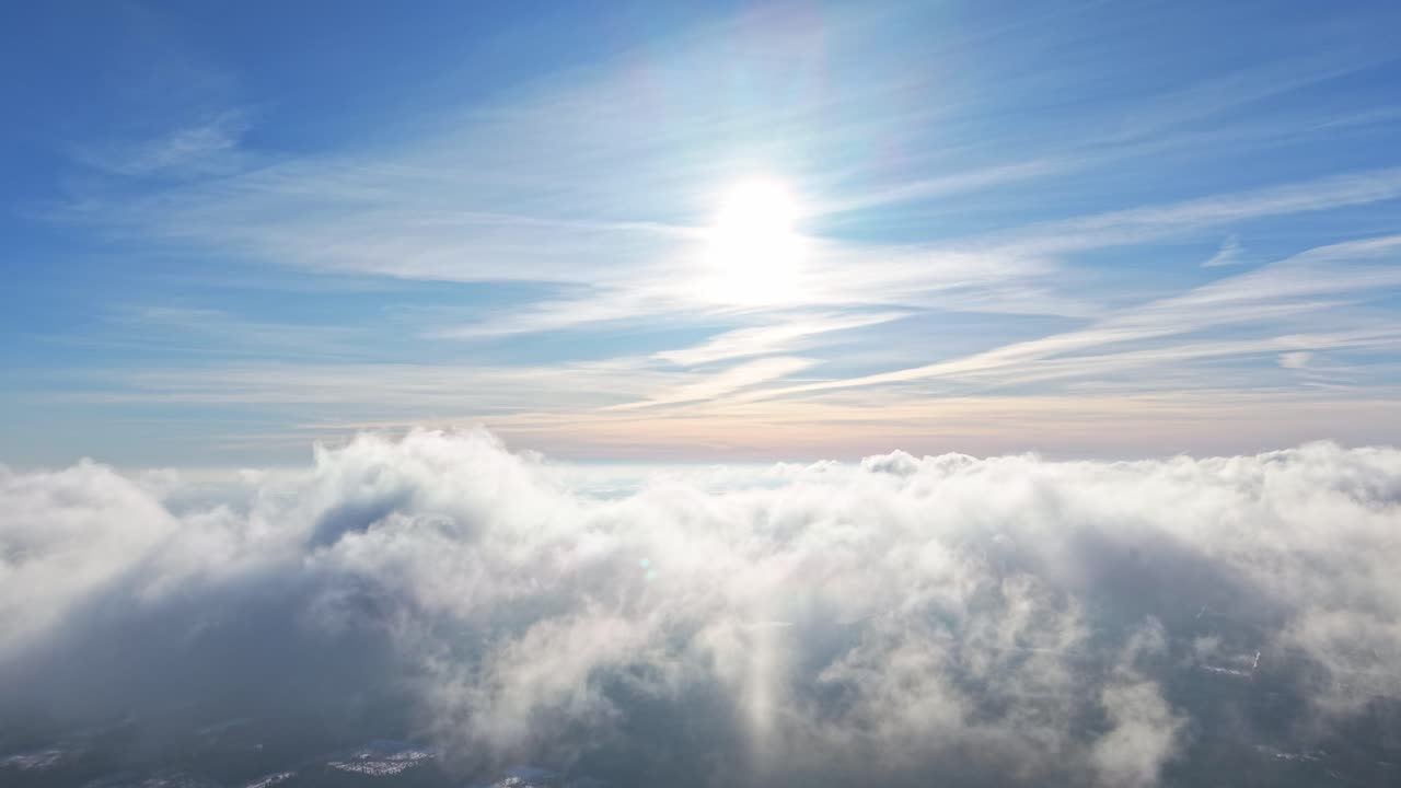 Strato di nuvole illuminato dal sole visto dall'alto con cielo azzurro e atmosfera soffusa, sfondo vuoto, pacifico e rilassante.