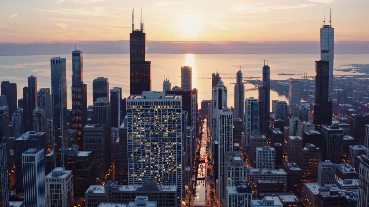 Aerial view of a city skyline at sunset, showcasing skyscrapers and a glowing horizon