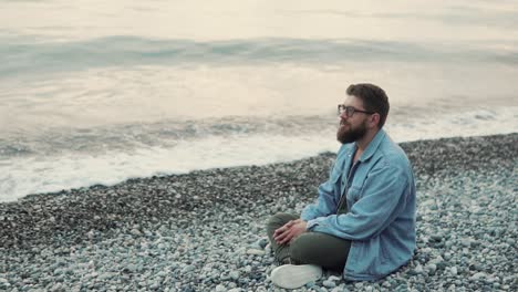 hombre meditando en la playa al atardecer