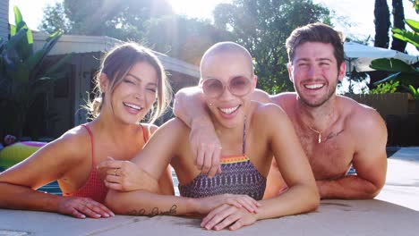 Portrait-Of-Group-Of-Friends-Outdoors-Relaxing-In-Swimming-Pool-And-Enjoying-Summer-Pool-Party