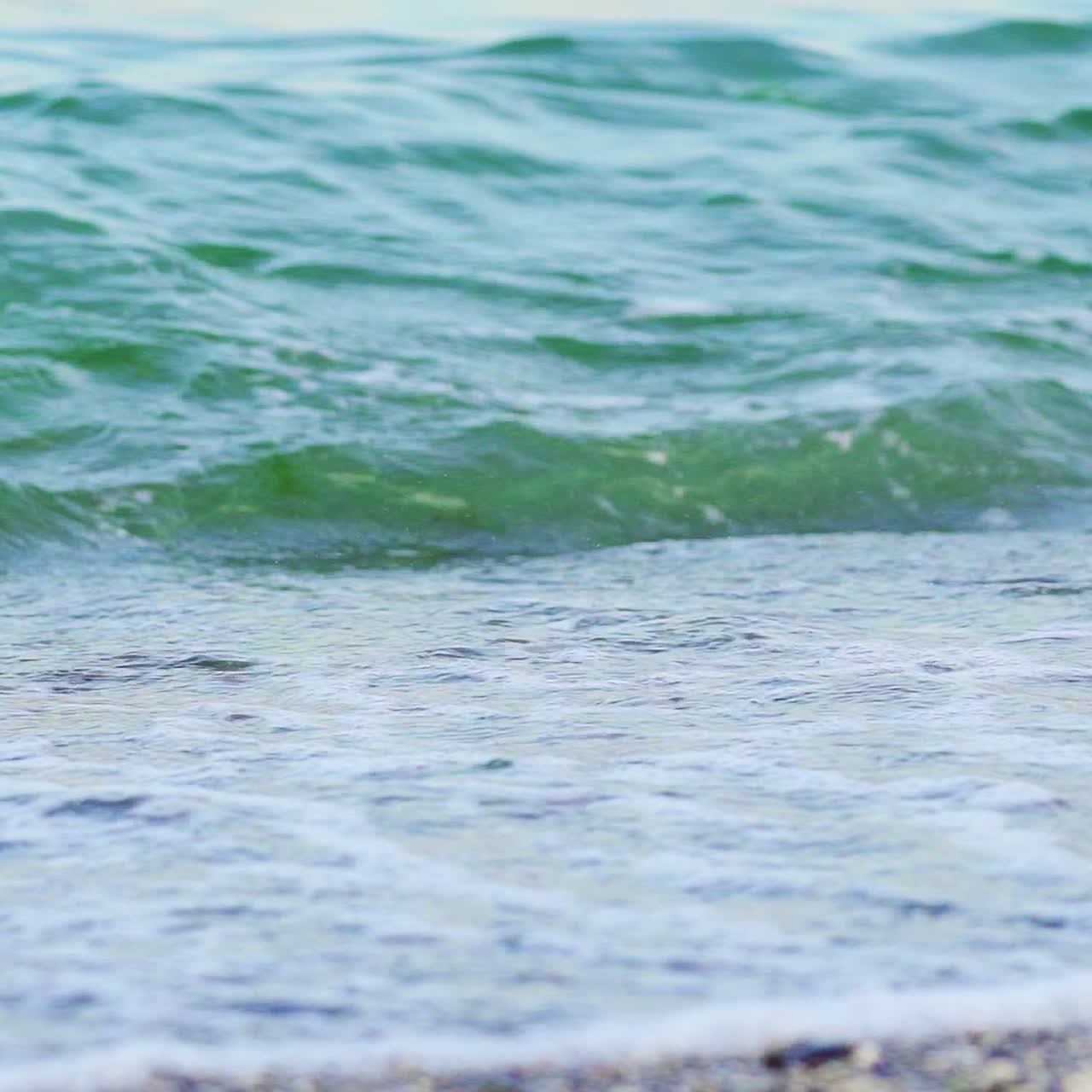 Natural sea marine oceanic background with big waves forming white foam on the shore. Close-up beach of blue water waves crashing.