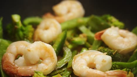 unrecognizable person putting stir fried prawns