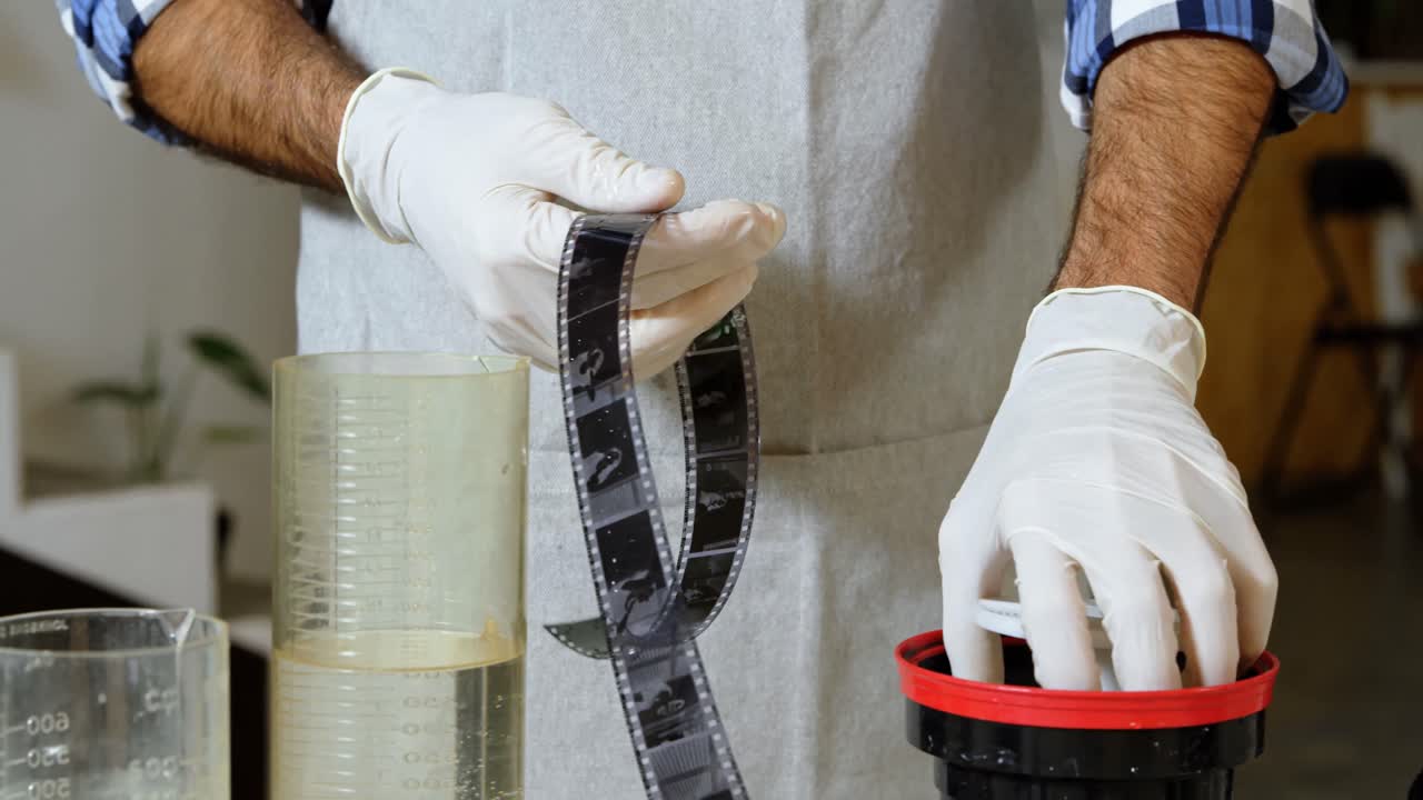 fotógrafo masculino desarrollando la cinta de la cámara 4k