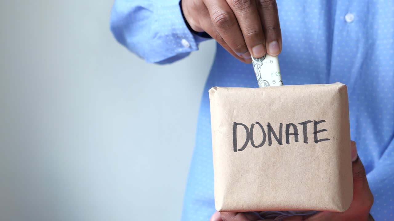 persona que dona dinero a una caja de donaciones