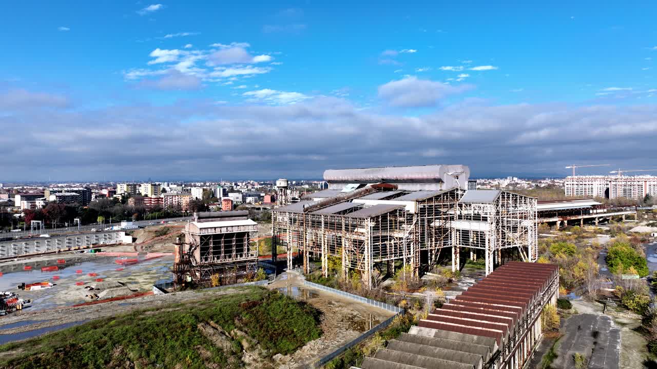 View of a vast, disused industrial site in Milan, awaiting urban renewal and regeneration. Historical footage representing the city's manufacturing past and its future development