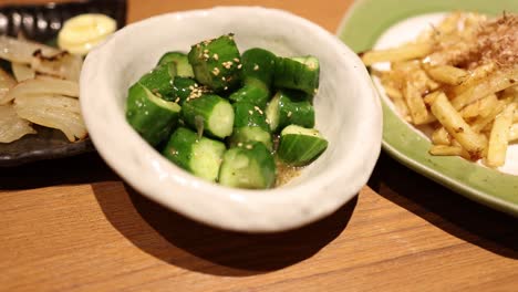 chopsticks tossing a fresh cucumber salad dish