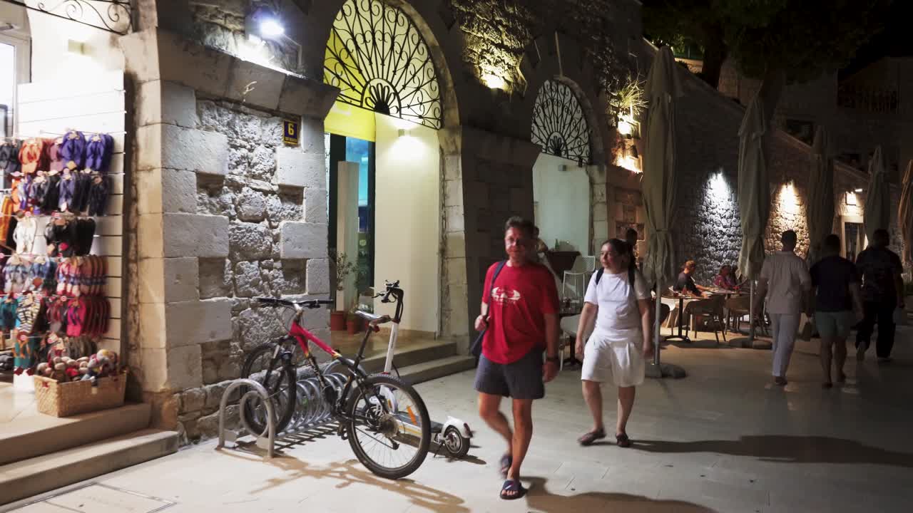 July 30, 2024 Bol, Croatia - Night Scene of Bol Harbor Famous Torurist Resort. Party Cruise Sailboats and Traditional Fishing Boats Docked in Harbor