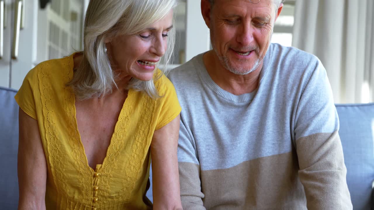 벤치 4k에서 사진 앨범을 보는 고령 커플