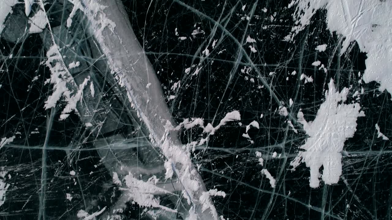 내부에 균열과 거품이있는 파란색 투명한 은 얼음 위의 공중. 얼어붙은 베이칼 호수. 자연 랜드마크. 겨울 풍경. 인기있는 관광지. 위에서 아래로 볼 수 있습니다.