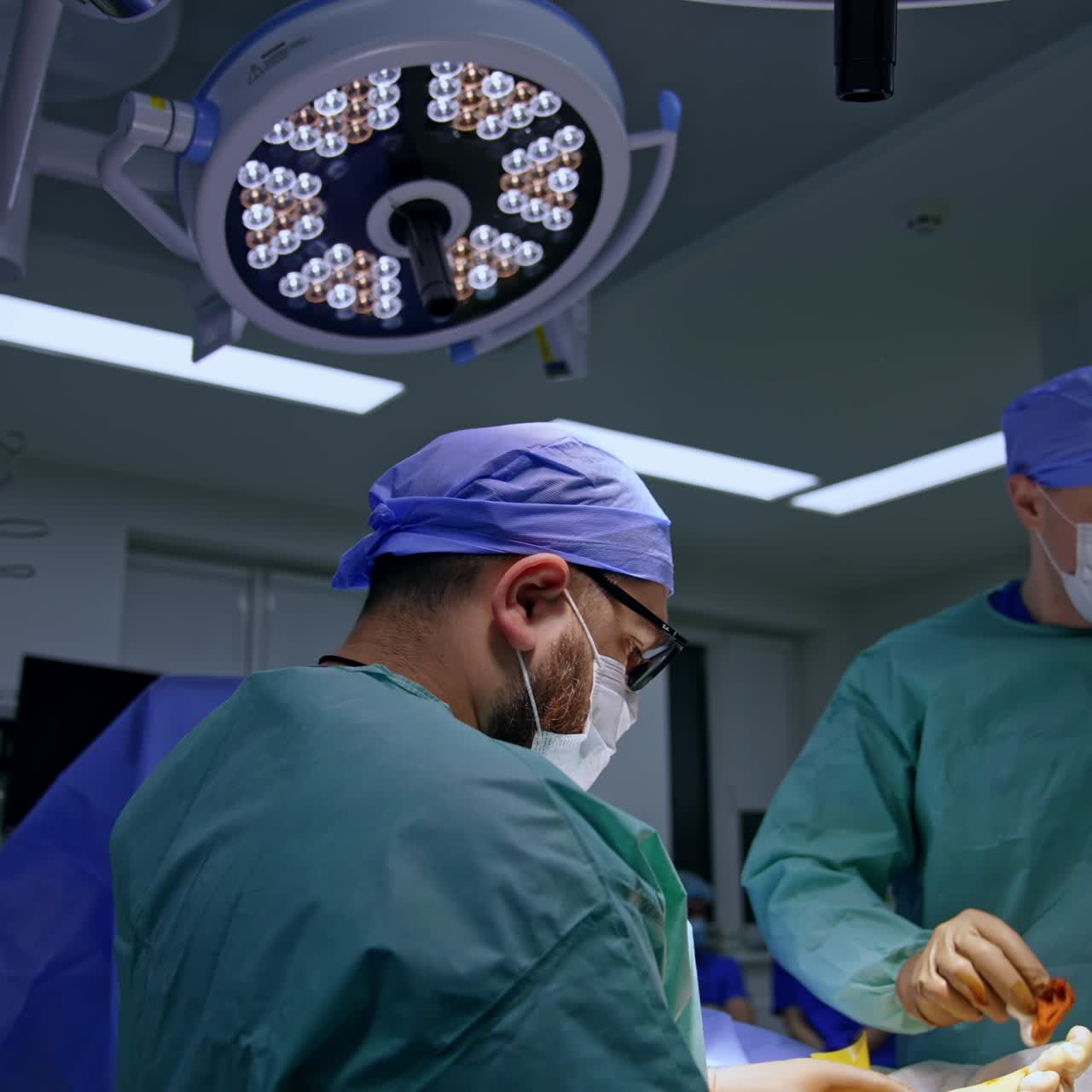 Surgical team working in the operational theatre. Doctor uses sponge on the operated foot applying medicines