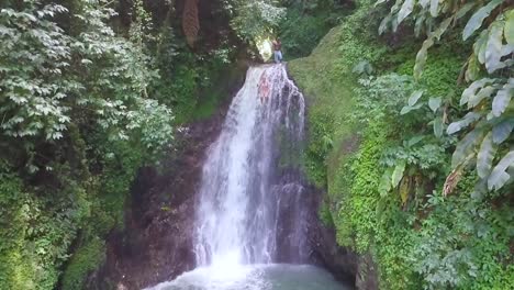 mujer en cámara lenta saltando de una cascada a una piscina en una selva tropical granada caribe