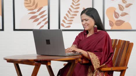 happy indian woman using laptop