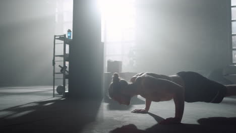 man standing in plank. guy doing push ups during fitness session in sport club