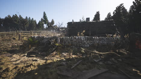 Abandoned stone structure with fallen logs amidst overgrown landscape