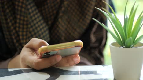 primer plano de mujeres con la mano sujetando un teléfono inteligente
