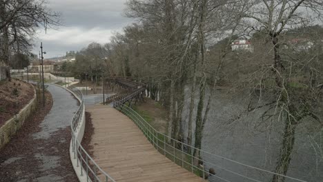 riverside walkway with overhead bridge in portugal